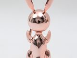 a metal rabbit figurine sitting on its hind legs