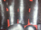 une image représentant un tableau composé de formes noires et rouges sur un fond rouge