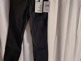 a pair of black pants hanging on a hanger in front of a white curtain