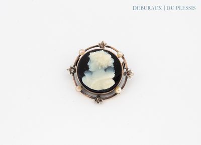 un gros plan sur une broche représentant une femme vêtue d'une robe noire et blanche