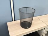 a trash can sitting on top of a shelf in a bathroom