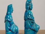 pair of blue ceramic figurines of a woman and a man sitting on a stool
