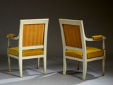 pair of chairs with yellow upholstered cushions in a dark room