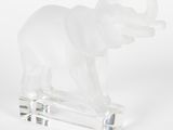 figurine d'éléphant en verre transparent posée sur un socle transparent, sur fond blanc