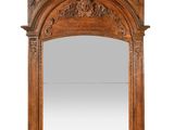 a large carved wood mirror with an arched top