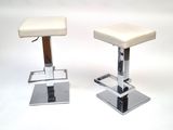 pair of chrome and leather bar stools with a white upholstered seat
