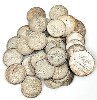 une pile de pièces d'argent posée sur une surface blanche