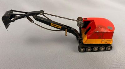 a red and yellow toy truck that is on a white surface