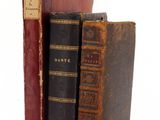 two old books sitting on top of each other on a table