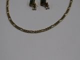 a close up of a necklace and earring on a white surface