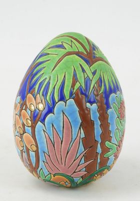un œuf décoré, posé sur une surface blanche