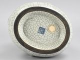 a white and brown bowl with a blue and white design on it