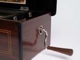 a small wooden box with a handle on a white surface