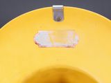 a yellow toilet bowl with a sticker on it