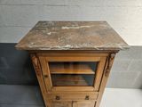 a small wooden cabinet with a marble top on the floor