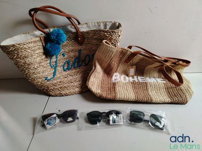 deux sacs et des lunettes de soleil posés par terre, l'un à côté de l'autre