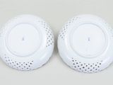 pair of white porcelain plates with holes and holes on them
