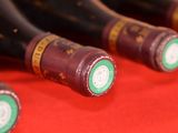 several bottles of wine are lined up on a red surface