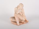 statue d'une femme assise sur un rocher, les mains posées sur les genoux