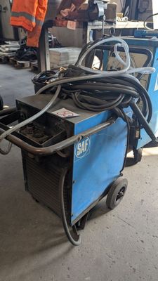 une photo d'une soudeuse dans un garage, à côté d'autres équipements