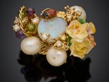un gros plan d'une bague ornée de perles et de fleurs sur un fond noir