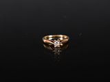 une bague en or sertie d'un diamant sur un fond noir