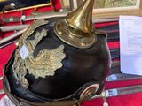 a helmet with a gold decoration on it sitting on a red cloth