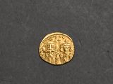 a close up of a gold coin on a black surface