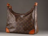 a close up of a louis vuitton bag on a gray surface