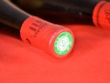 two bottles of red lipstick sitting on top of a red cloth