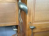 une statue métallique représentant un oiseau, posée sur une table en bois