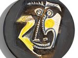 a black plate with a painting of a man on it
