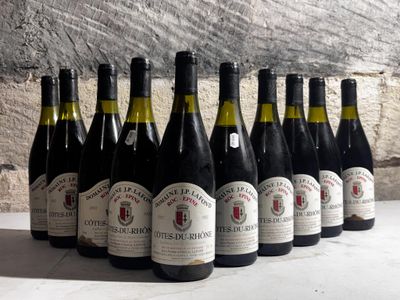 several bottles of wine are lined up in a row in front of a stone wall