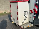 un camion blanc avec une bande rouge et blanche à l'arrière