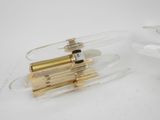 two clear glass lamps with gold trims are on a white surface