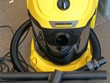 yellow and black vacuum cleaner sitting on top of a floor next to a hose
