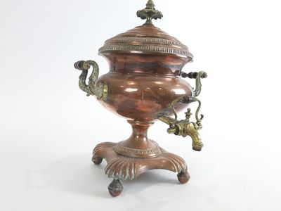 une grande urne en métal ornée d'un oiseau