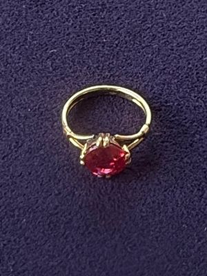a gold ring with a red stone in the middle