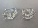 une paire de cendriers en verre transparent posés sur une table
