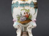 a white and blue vase with a painting on it