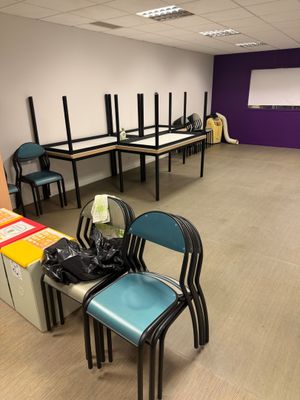 une salle équipée de chaises, de tables et d'un projecteur