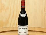 une bouteille de vin posée sur un tonneau en bois