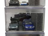 three clear boxes with toy cars in them