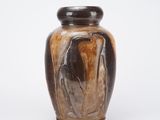 un vase marron avec un couvercle noir posé sur une surface blanche