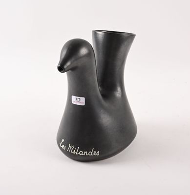 un vase noir orné d'une anse en forme d'oiseau sur fond blanc