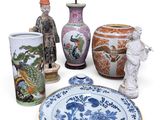 several vases, plates, and figurines are displayed on a white surface