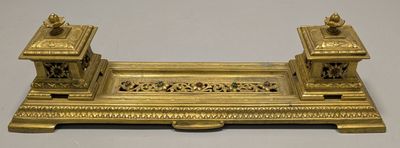 an image of a gold plate with two candles on top of it
