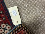 an image of a red and blue rug with a tag on it
