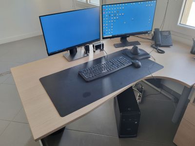 a desk with two monitors and a keyboard on it