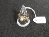 une bague posée dans un support en verre